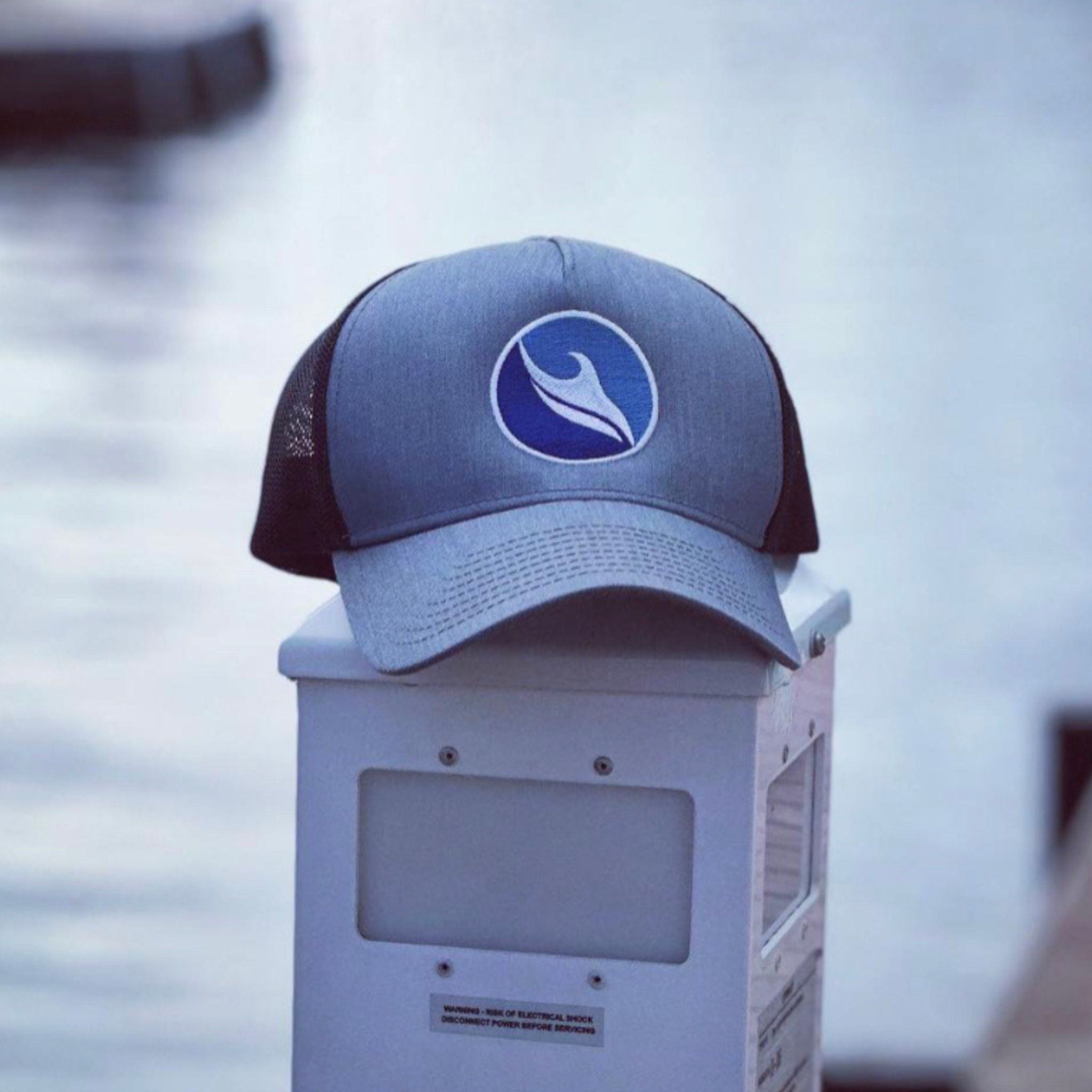 Ocean Duty brand trucker hat sitting on a boat dock at the ocean.