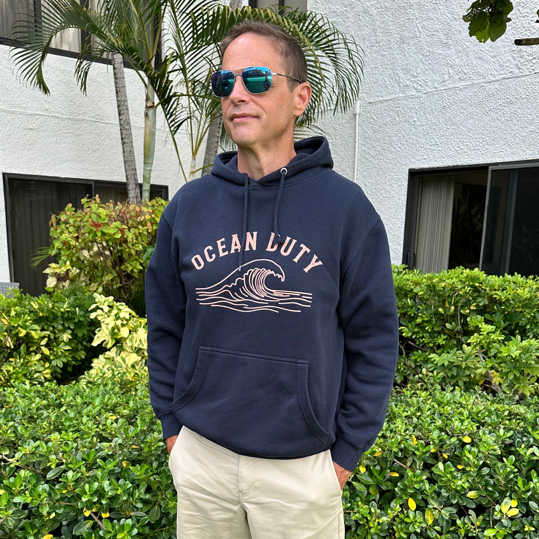 A man wearing a navy blue hoodie with &