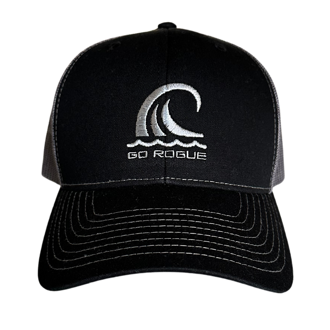 Front of a a black and charcoal grey trucker hat with ocean wave go rogue text embroidery