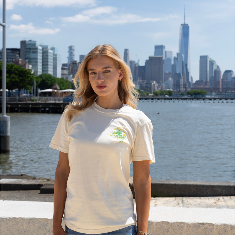 A woman wearing an ivory t-shirt with a bright green jellyfish graphic and print.