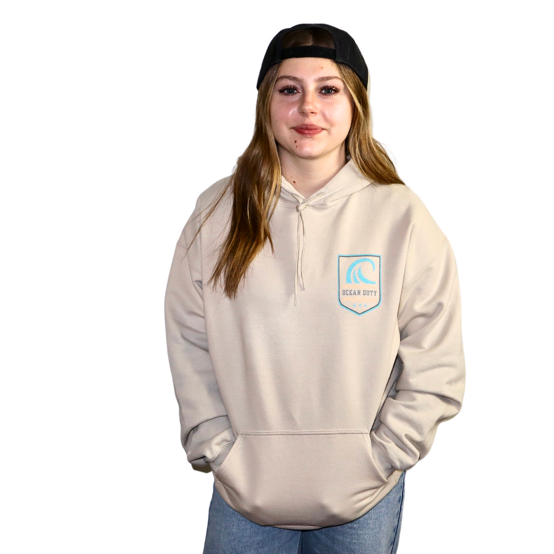 Girl wearing Hoodie in Sand Color with a large wave a Go Rogue Graphic