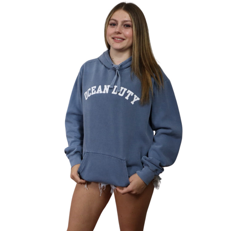 Girl wearing A blue hoodie in a blue jean color, featuring a beautifully detailed mermaid graphic on the back, perfect for ocean lovers and casual fashion enthusiasts