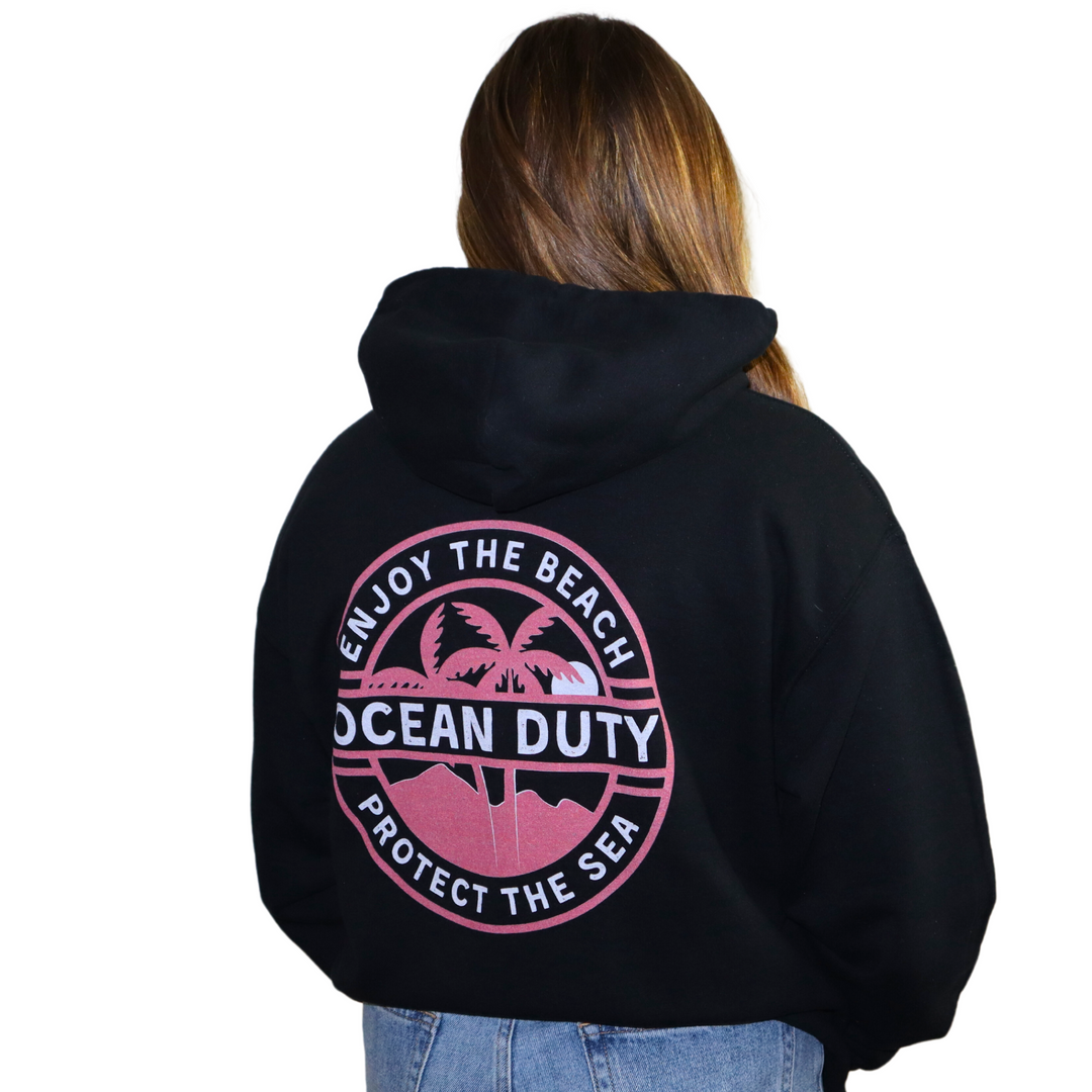 Girl wearing black hoodie with a ocean and beach graphic text