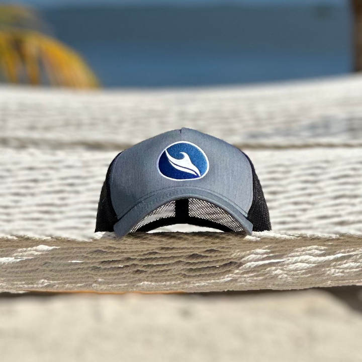 Ocean Duty brand Trucker hat sitting on a hammock at the beach.