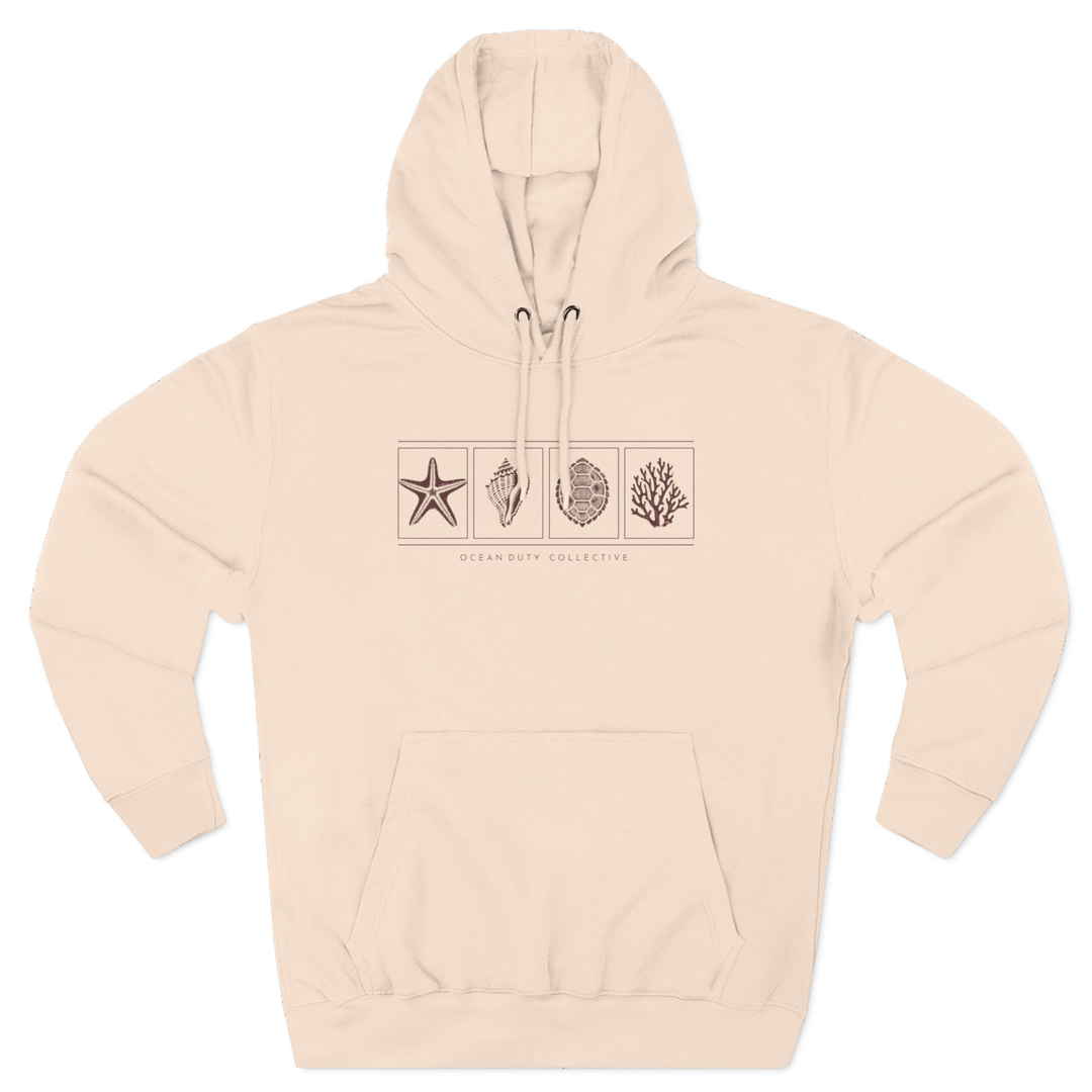 A model wearing the premium Ocean Duty Collection Hoodie in Pale Pink, styled casually for a coastal lifestyle look.