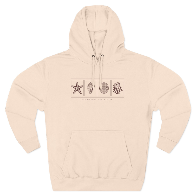 A model wearing the premium Ocean Duty Collection Hoodie in Pale Pink, styled casually for a coastal lifestyle look.